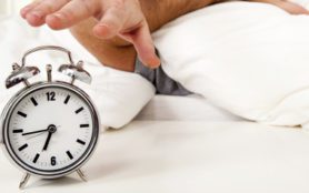 sleeping man disturbed by alarm clock early morning